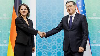 Außenministerin Baerbock und der usbekische Außenminister Vladimir Norov schütteln sich die Hände