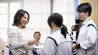 Außenministerin Annalena Baerbock spricht mit Schülerinnen und Schülern der Schule Nr. 42 in Tianjin.