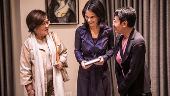 Außenministerin Baerbock steht lachend zwischen der Journalistin und Friedensnobelpreisträgerin Maria Ressa und der ehemaligen Senatorin Leila de Lima