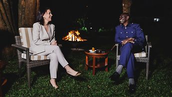Außenministerin Baerbock sitzt neben dem kenianischen Staatspräsidenten William Ruto in einem Garten und die beiden unterhalten sich